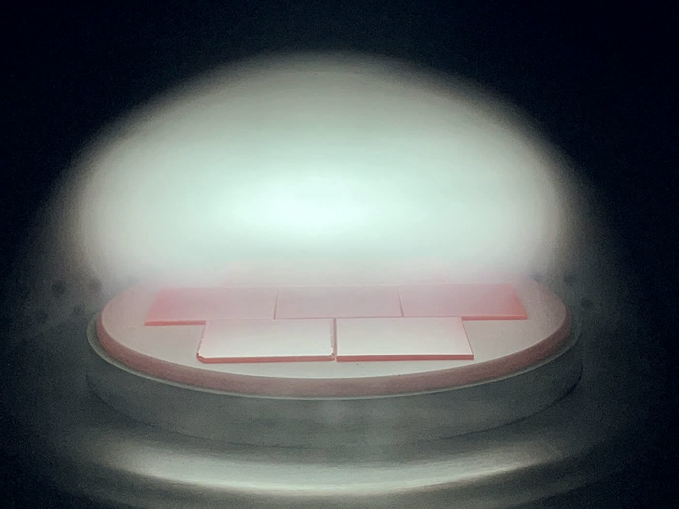Plasma glowing over the seed plate inside a sealed CVD chamber
