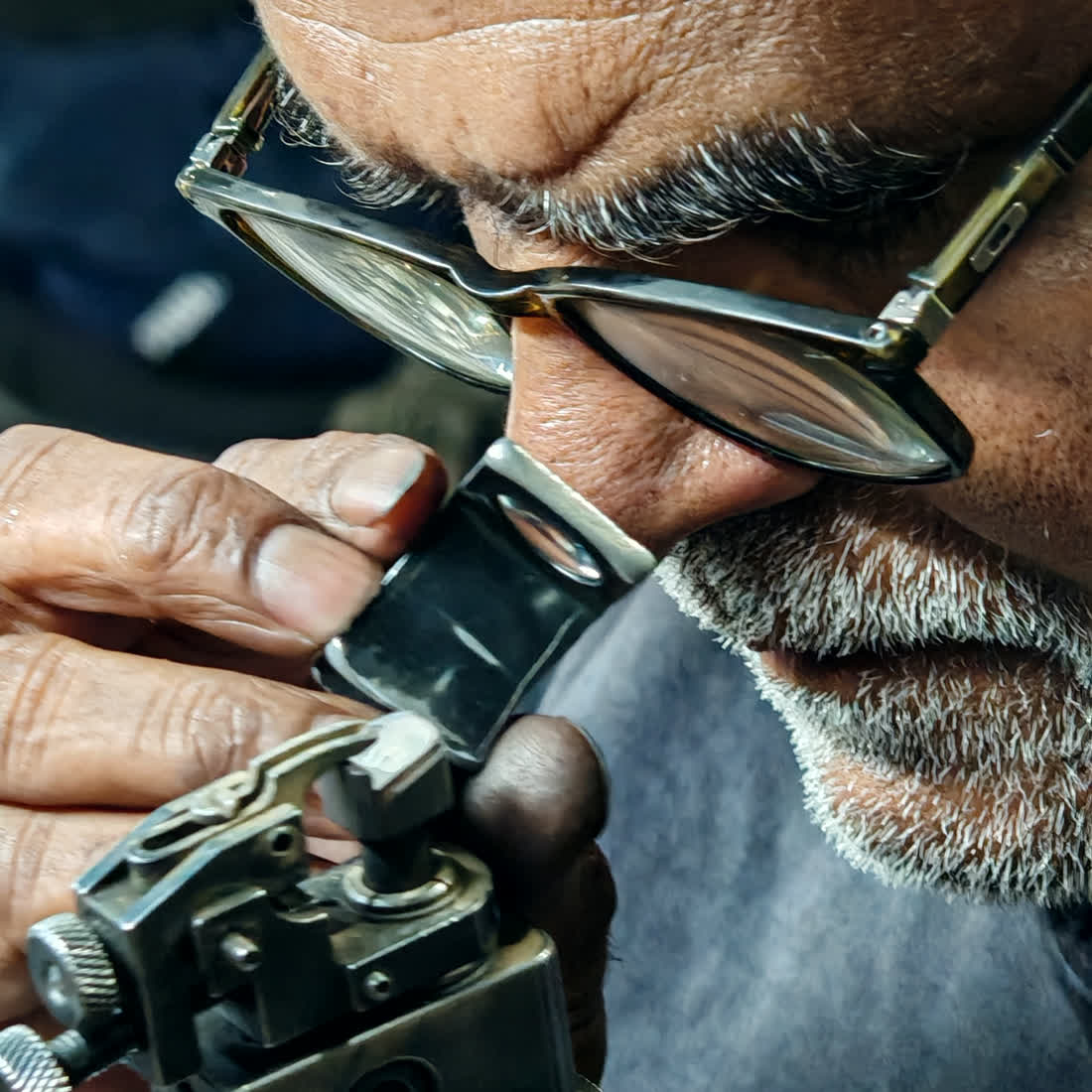 Senior artisan reading a grown diamond through a loupe